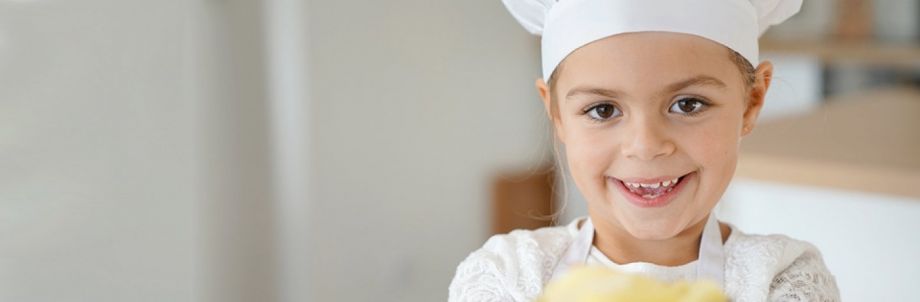 Bimba con cappello da chef che sorride