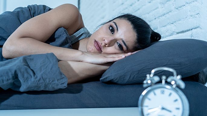 Donna che guarda l’orologio e non riesce a dormire