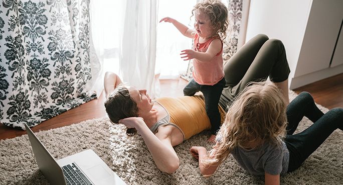 Donna fa ginnastica in casa insieme ai bambini