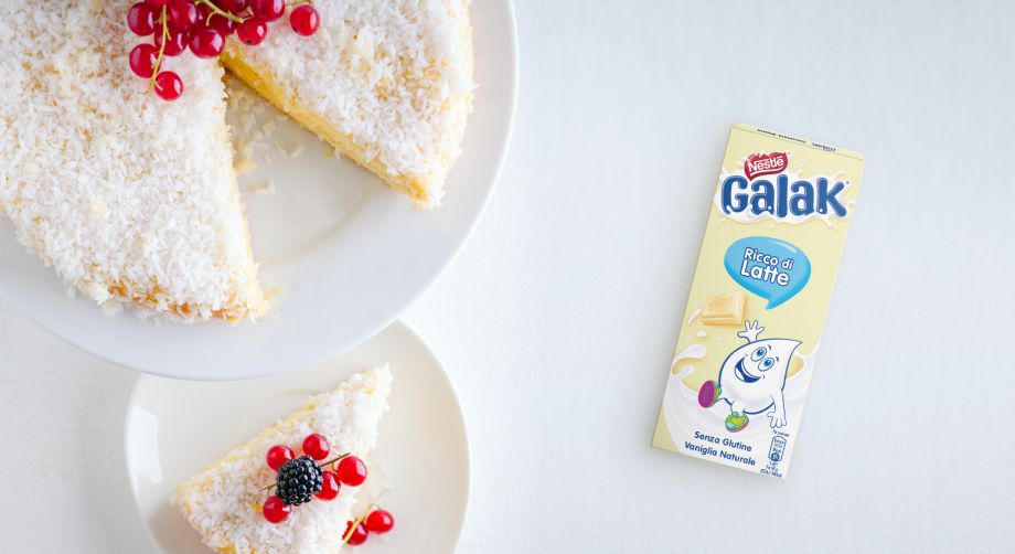 Tavola vista dall’alto con torta cioccolato bianco e cocco e confezione di Nestlè Galak bianco